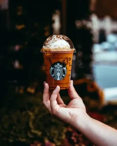 Person holding a customized Starbucks iced coffee cup featuring digital marketing tips for small businesses